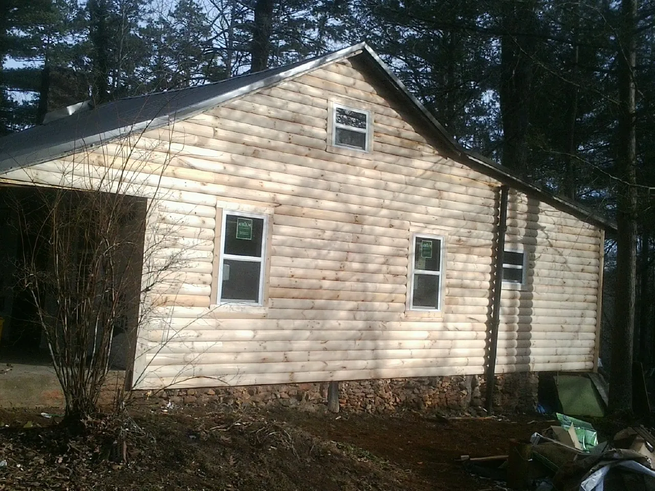 New log siding and dark metal roofing on a gable end in Luray