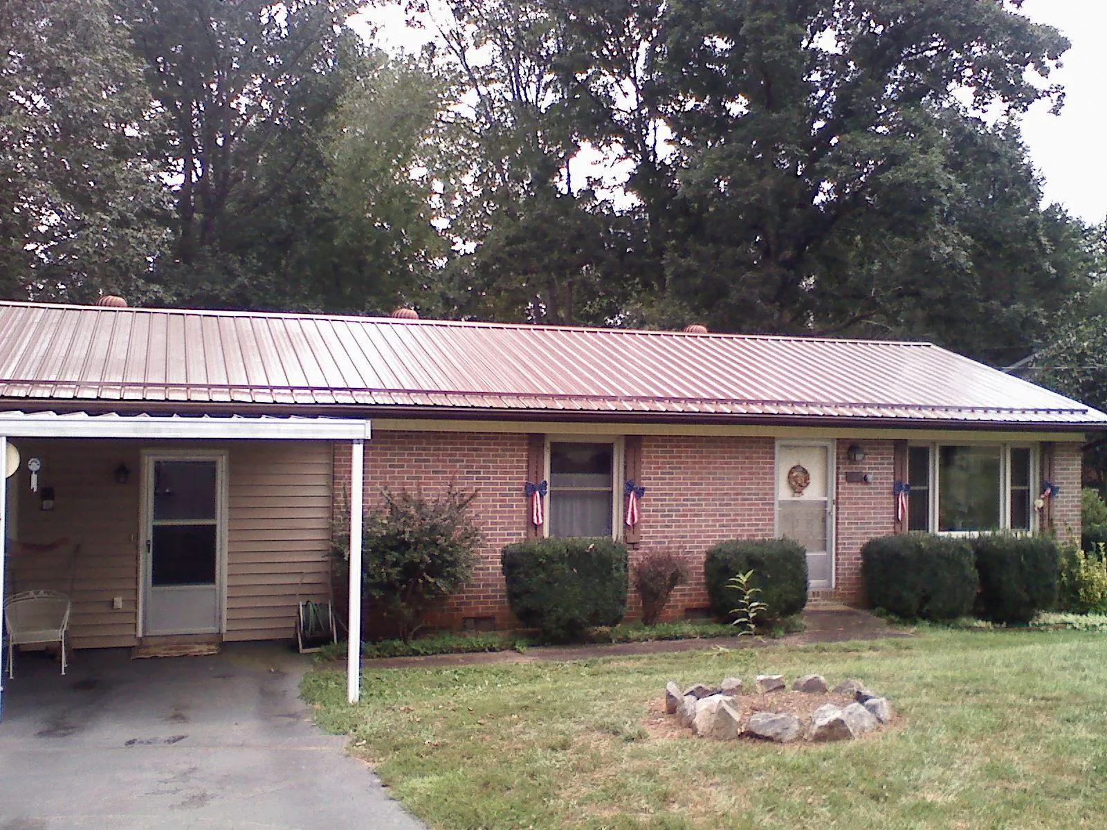 Bronze metal roof and carport on a brick ranch home — Roof Repair work by our crew in Luray